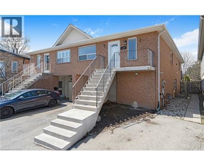 A two-story brick house with a car parked in front.