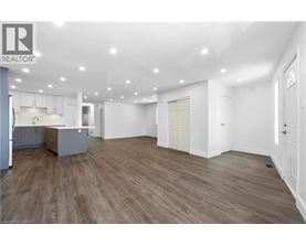 A spacious room with wooden flooring and white walls.