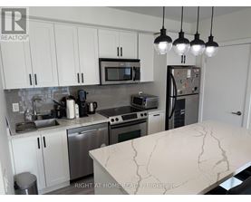 A kitchen with a marble counter top and stainless steel appliances.