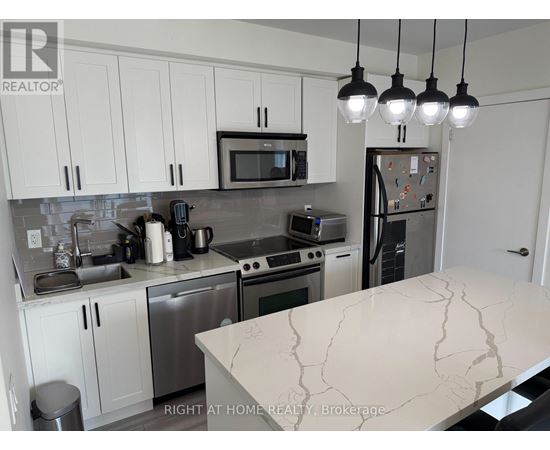 A kitchen with a marble counter top and stainless steel appliances.