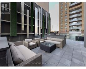 A patio area with furniture and a building in the background.