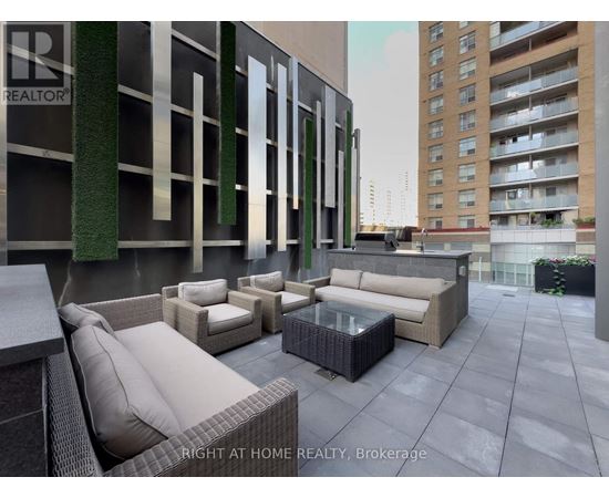 A patio area with furniture and a building in the background.