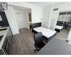 A bedroom with a bed, chair, and a desk.