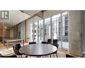 A modern dining room with a glass table and chairs.