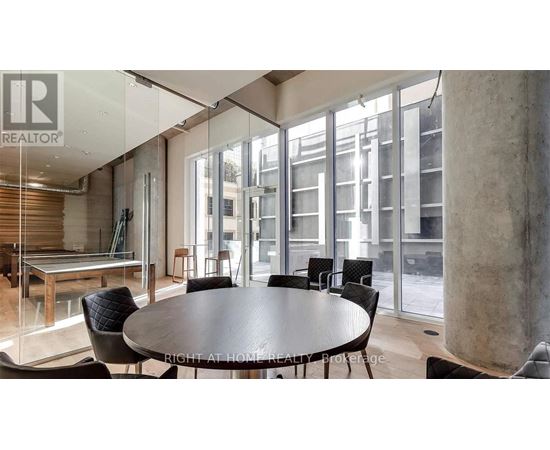 A modern dining room with a glass table and chairs.
