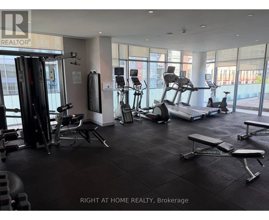 A gym with a variety of equipment including treadmills, weights, and exercise machines.