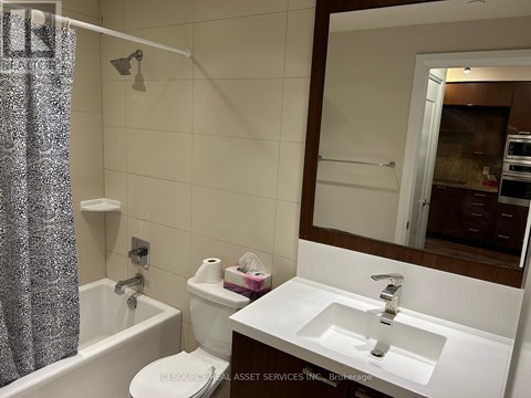 A bathroom with a white sink, toilet, and shower curtain.