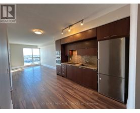 A kitchen with wooden floors and stainless steel appliances.