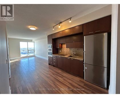 A kitchen with wooden floors and stainless steel appliances.