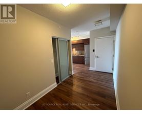 A hallway with wood floors and white walls.