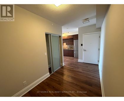 A hallway with wood floors and white walls.