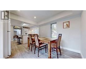 A dining room with a wooden table and chairs.