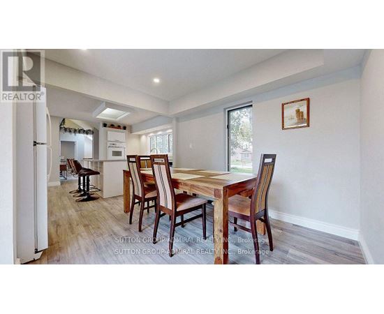 A dining room with a wooden table and chairs.