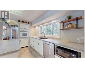 A kitchen with a white oven and white cabinets.