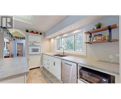 A kitchen with a white oven and white cabinets.