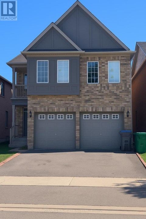 A two-story house with a garage and a driveway.