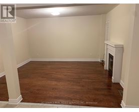 A room with a fireplace and wood flooring.