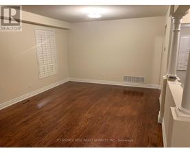 A room with wooden flooring and white walls.