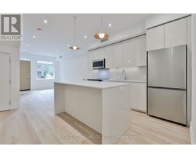 A modern kitchen with a refrigerator, microwave, and sink.