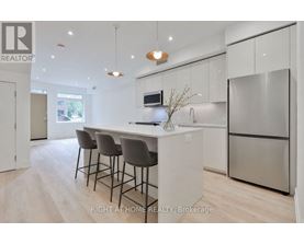 A modern kitchen with a bar area and a refrigerator.