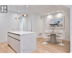 A modern kitchen with a white cabinet and a wooden dining table.