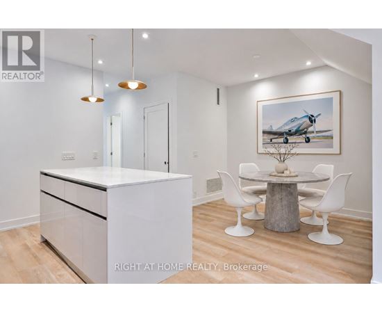 A modern kitchen with a white cabinet and a wooden dining table.