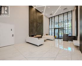 A white reception area with a glass wall and a white bench.