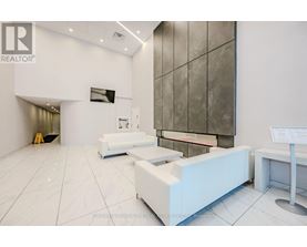 A white reception area with a large screen and a white reception desk.