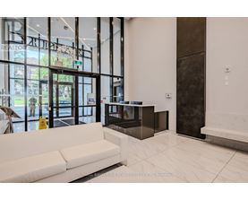 A real estate office with a white couch and a yellow spray bottle.