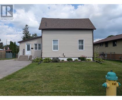 A house with a green lawn and a yellow fire hydrant in front.