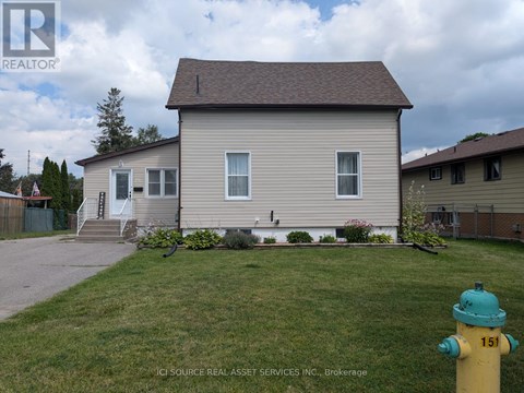 A house with a green lawn and a yellow fire hydrant in front.