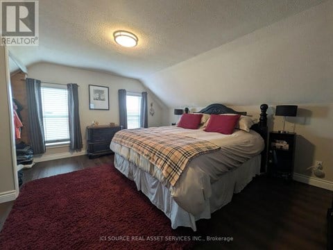 A bedroom with a bed, nightstand, and window.