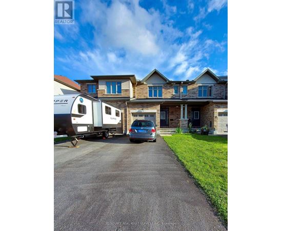 A house with a car and a camper van parked in front.