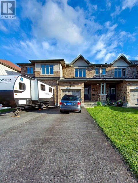 A house with a car and a camper van parked in front.
