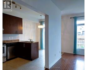 A kitchen with dark wood cabinets and a stainless steel dishwasher.
