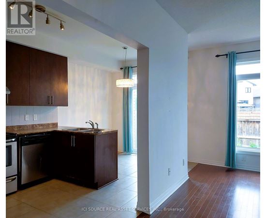 A kitchen with dark wood cabinets and a stainless steel dishwasher.