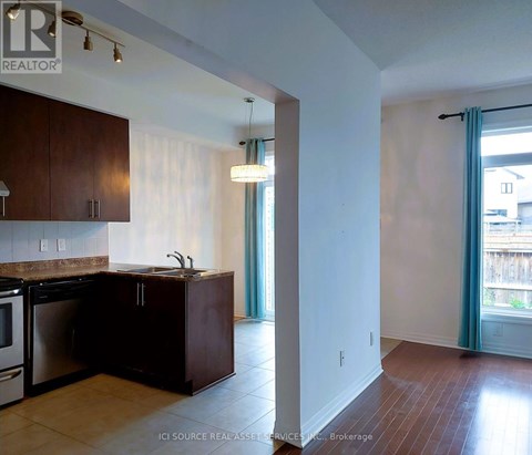 A kitchen with dark wood cabinets and a stainless steel dishwasher.