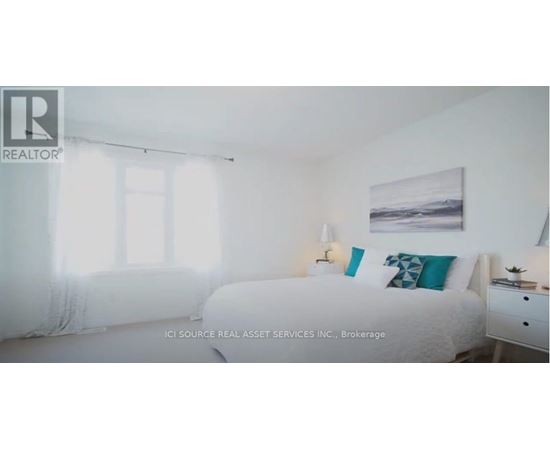 A bedroom with a bed, nightstand, and window with curtains.