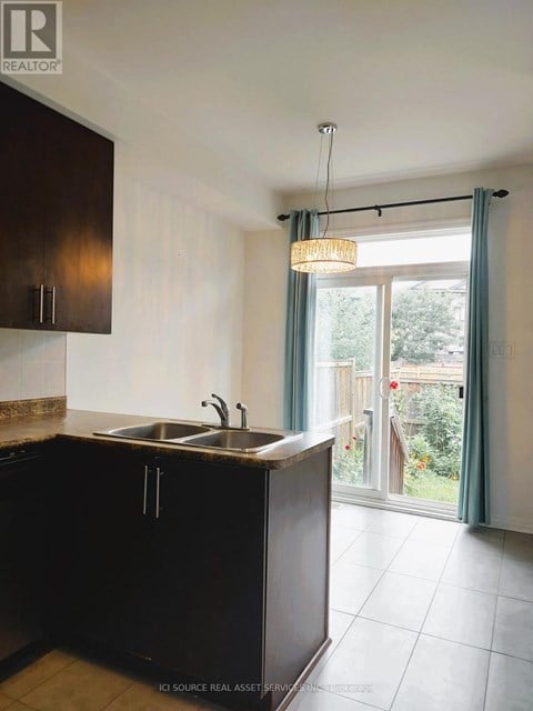 A kitchen with brown cabinets and a sink.