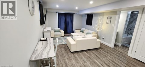 A living room with a white couch and a television on the wall.
