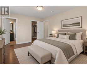 A bedroom with a large bed and a bench in front of it.