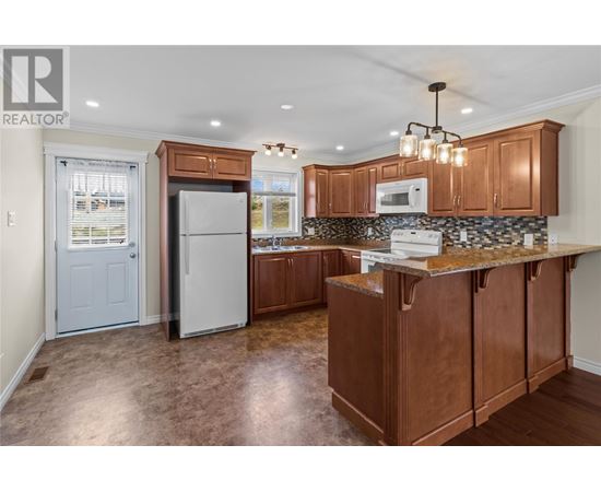 A kitchen with brown cabinets and a white fridge.