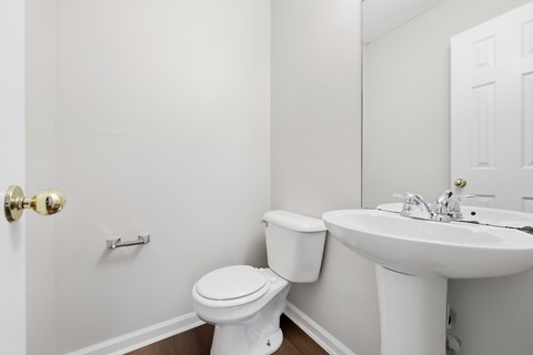 A white toilet sits next to a white sink in a bathroom.