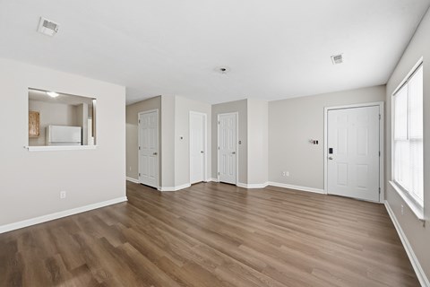 A large empty room with wooden floors and white walls.