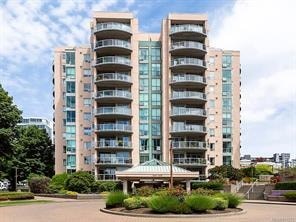 A large, modern apartment building with a landscaped courtyard in front.