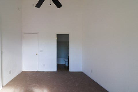 A room with a ceiling fan and a door.