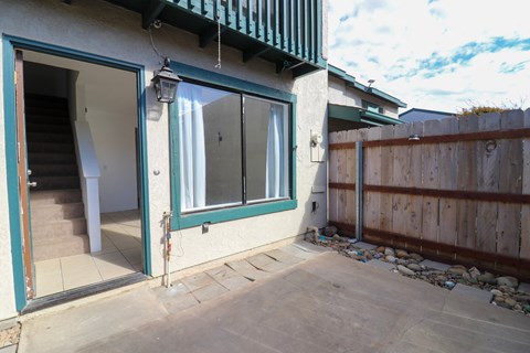 A house with a green awning and a white door with a glass window.