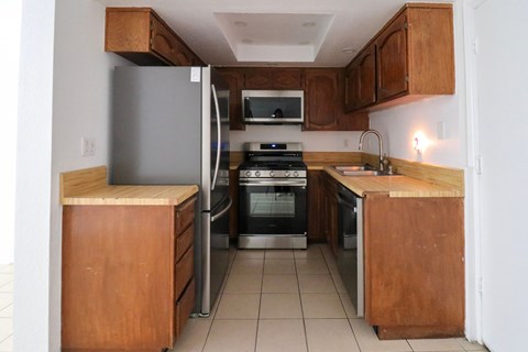 A kitchen with wooden cabinets and a white refrigerator.
