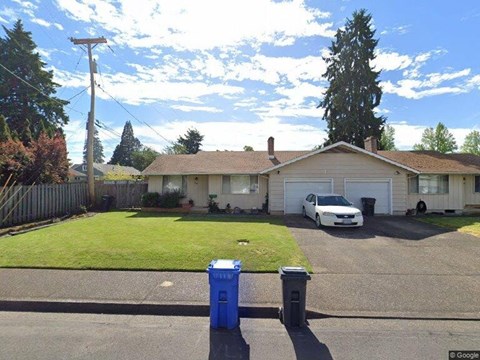 A white car is parked in the driveway of a house.