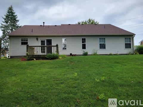 A house with a grey roof and a white fence.